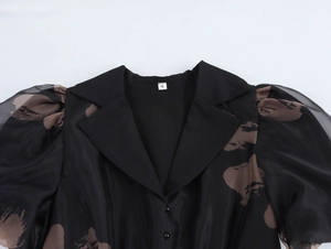 Détail de la robe en organza français avec col chemise, manches bouffantes et motif abstrait