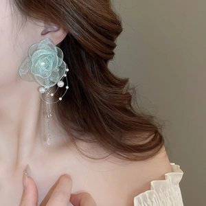Close-up of elegant light green lace rose earring with pearls and silver chain drop