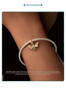 Macro shot of a gold-plated bee charm with sparkling crystals on a mesh weave bracelet