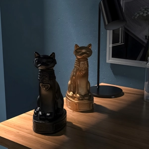 Detailed close-up of matte black and shiny gold Egyptian Bastet cat goddess statues