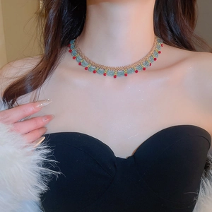 Detailed view of handmade beaded choker necklace with green and gold woven crystal beads
