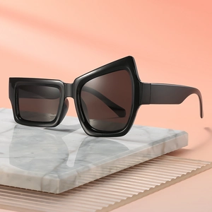 Lunettes de soleil noires irrégulières sur un support élégant en marbre blanc