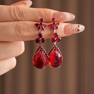 Detail of ruby red teardrop earrings with zircon flower studs and silver prong setting