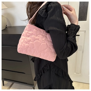 Détail du sac cabas rose matelassé avec motifs de cœur et bandoulière en tissu doux