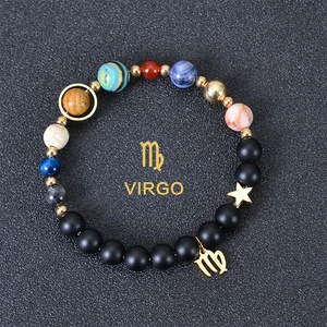 Detail of Virgo constellation planet bracelet with black matte beads and gold charm