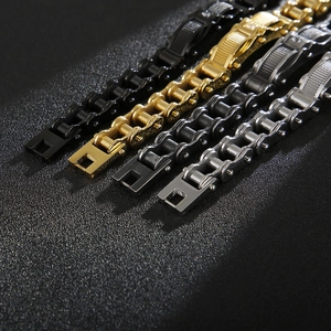 Dettaglio di bracciali a catena meccanica per moto in acciaio nero, oro e argento