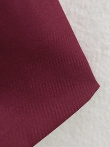 Dettaglio del tessuto twill bordeaux che mostra la trama fine del blazer a doppiopetto