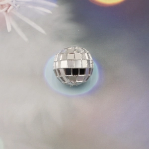 Macro shot of silver disco ball ornament with reflective mosaic mirror glass facets