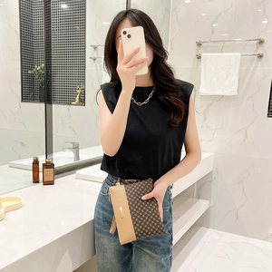 Fashionable checkered pattern clutch bag with metal accent held by a model in casual setting