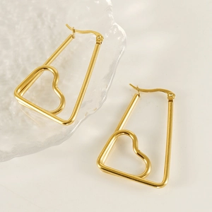 Elegant gold heart earrings in irregular geometric frames on textured glass surface