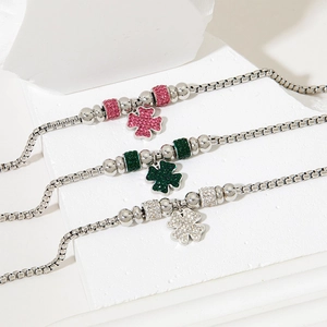Three lucky four-leaf clover bracelets in pink, green, and white with crystal pavé pendants