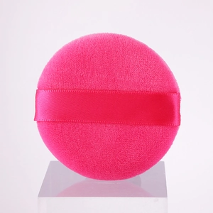 Pink plush round powder puff with ribbon handle on acrylic stand for flawless makeup