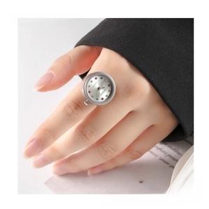 Close-up of a silver ring watch with colorful gemstone markers on a female finger