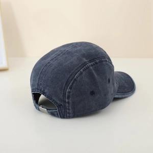 Detail of vintage washed denim five-panel kids baseball cap with metal buckle closure