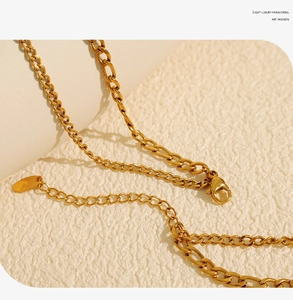 Vue macro du collier doré avec fermoir OT, mousqueton et chaînette d'extension