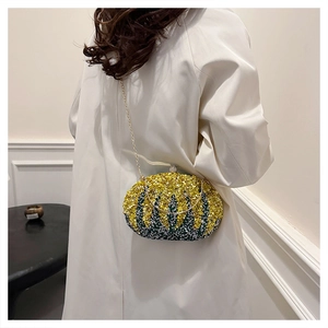 Close-up of luxury yellow-green gradient beaded evening bag with gold chain strap