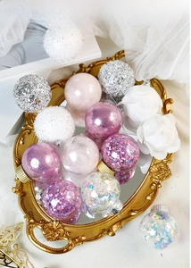 Macro shot of assorted white and purple Christmas ornaments with glitter and feathers