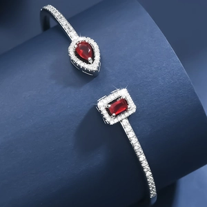 Detail view of adjustable silver cuff featuring teardrop and rectangle ruby stones