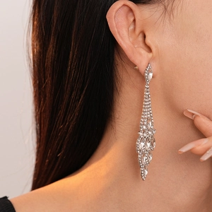 Dettaglio di orecchini pendenti scintillanti con strass indossati da una modella di profilo