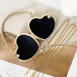 Open heart-shaped gold evening bag with black lining and elegant beaded handle