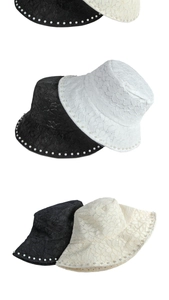 Detailed view of the hollow floral lace fabric and elegant pearl beads on the sun hat brim