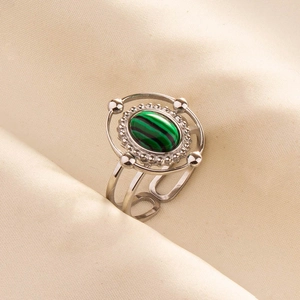 Detail of vintage 304 stainless steel ring with oval green malachite stone and retro beadwork