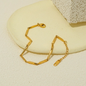 Détail du bracelet doré style bambou avec gravure S.STEEL sur la plaque de réglage