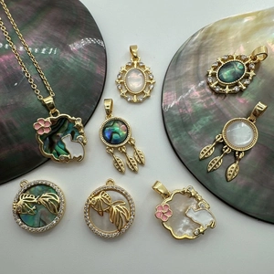 Macro shot of 18K gold-plated charms with shell inlays for DIY jewelry making