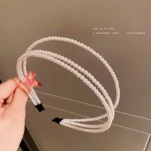 Detailed view of the three-layer pearl headband with secure fabric-wrapped ends for comfort