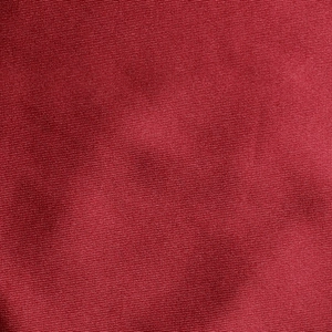 Gros plan sur un tissu satiné rouge foncé avec texture de soie et détails de tissage