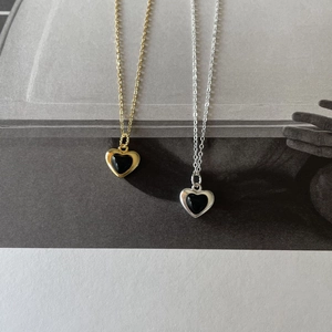 Close-up of 925 sterling silver necklaces with black heart pendants in gold and silver