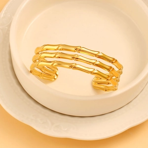 Detail of 18K gold-plated C-shaped bangle with three-layer bamboo texture on ceramic tray