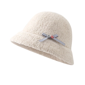 Winter beige faux fur bucket hat for women with bow and button detail on white background