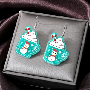 Detail of Christmas snowman and candy cane acrylic drop earrings on satin display