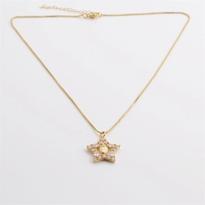 Detail of bohemian gold star pendant with faceted crystals and embossed central figure