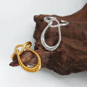 Minimalist knot geometric steel ring with micro-set zircons in gold and silver finishes