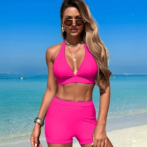 Zweiteiliger, pinker Halter-Bikini mit V-Ausschnitt Top und Mid-Rise Hose am Strand