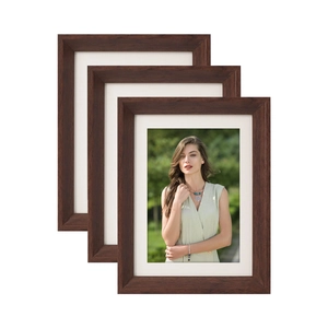 Three-piece set of dark brown wooden photo frames with white mats on a clean white background