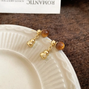 Detailed view of vintage gourd earrings with tiger eye stone and golden finish plating