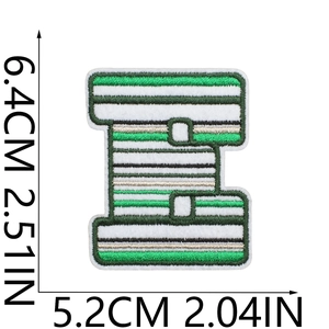 Close-up of letter E patch with green and white stripes and gold embroidery details