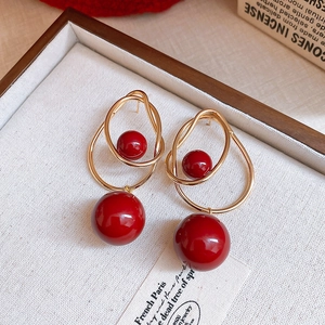 Détail macro de boucles d'oreilles vintage avec cercles dorés et perles rouges