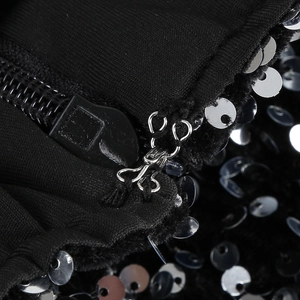 Macro detail of sequin dress featuring silver sequins and a black zipper closure system