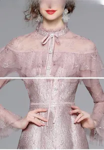 Détail de robe rose en tulle avec col à volants et boutons nacrés avec des paillettes