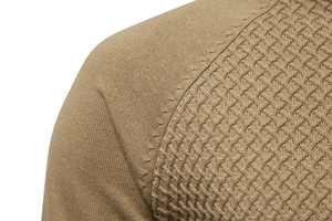 Macro detail of men's khaki cotton sweater showing mixed knit patterns and shoulder seam