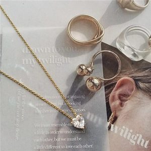 Chic heart-shaped zircon pendant necklace in gold finish on a vintage magazine