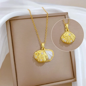 Dettaglio della collana d'oro con ciondolo a conchiglia, piccoli diamanti e madreperla