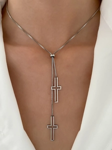 Detail view of silver Y-shaped box chain necklace with adjustable bead and cross pendants