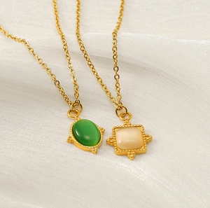 Détail de colliers en acier plaqué or 18 carats avec pierres naturelles vertes et blanches