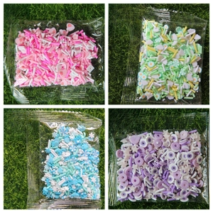Vue macro de divers confettis en pâte polymère en sets rose, vert, bleu et violet