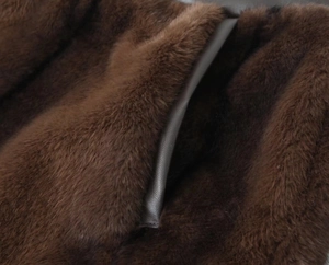 Detail shot of the long dark brown faux fur texture with high-quality leather piping trim